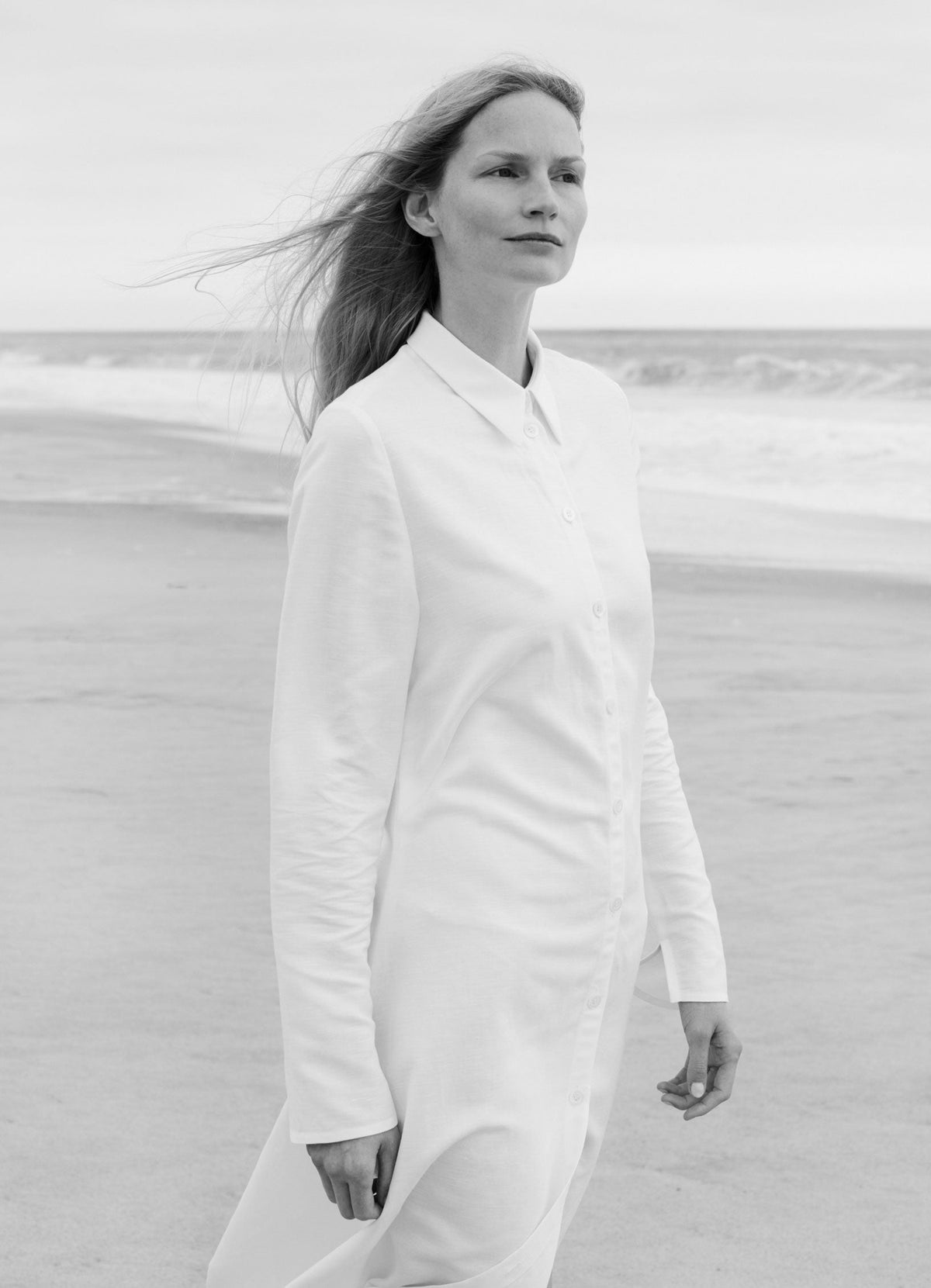 SCHOENBACH white shirt dress worn on the beach, a fluid silhouette shaped by movement and light structure