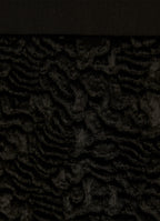 Close-up of textured velvet hem on black skirt