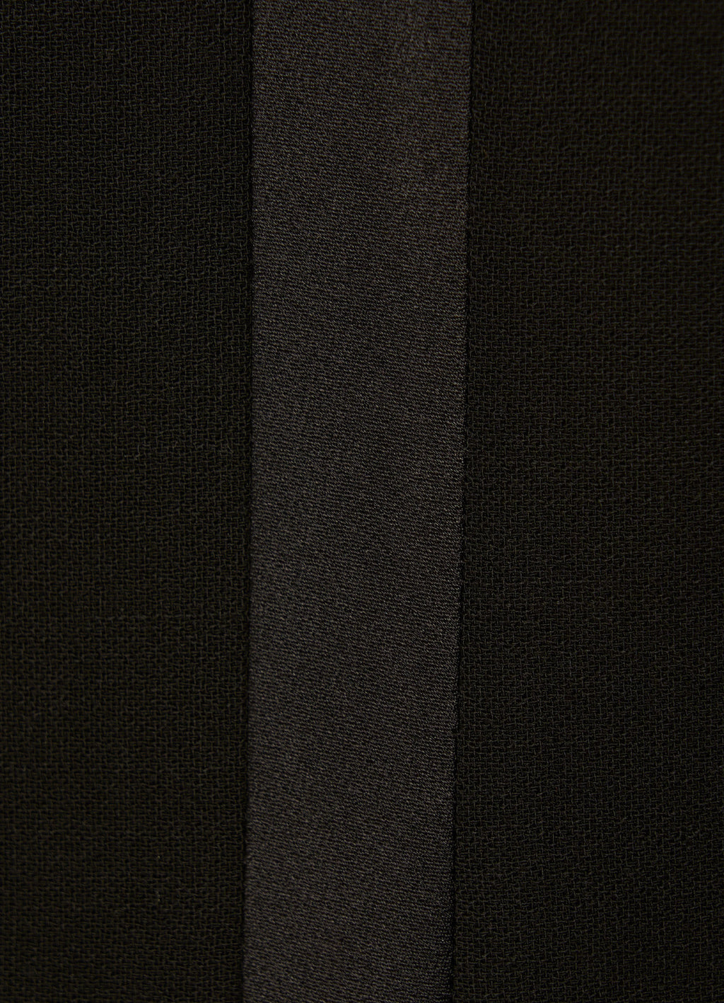 Close-up of black wool smoking trousers with satin side stripe