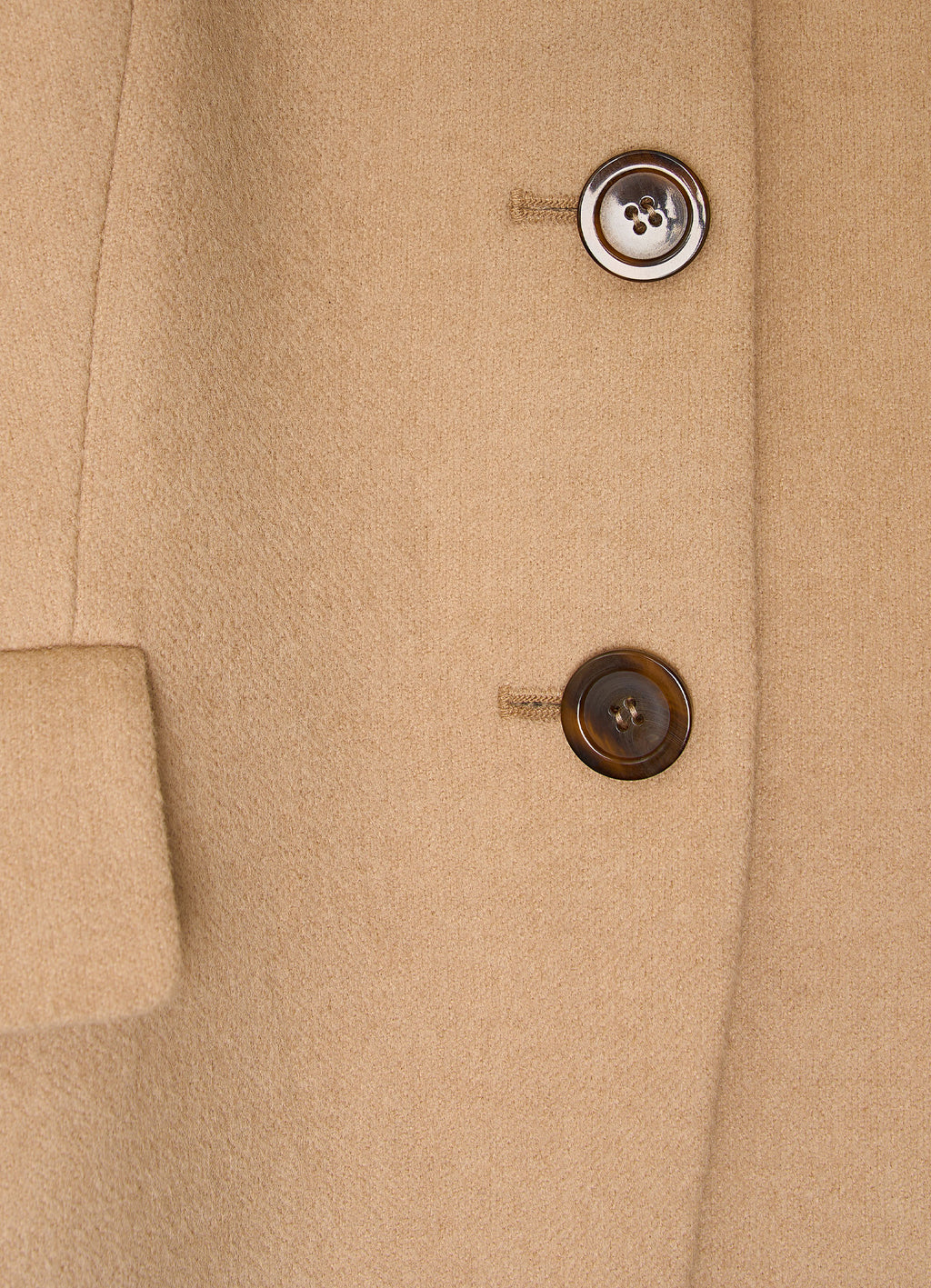 Detail of camel wool-cashmere jacket showing natural corozo buttons and refined textured fabric