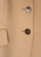 Detail of camel wool-cashmere jacket showing natural corozo buttons and refined textured fabric