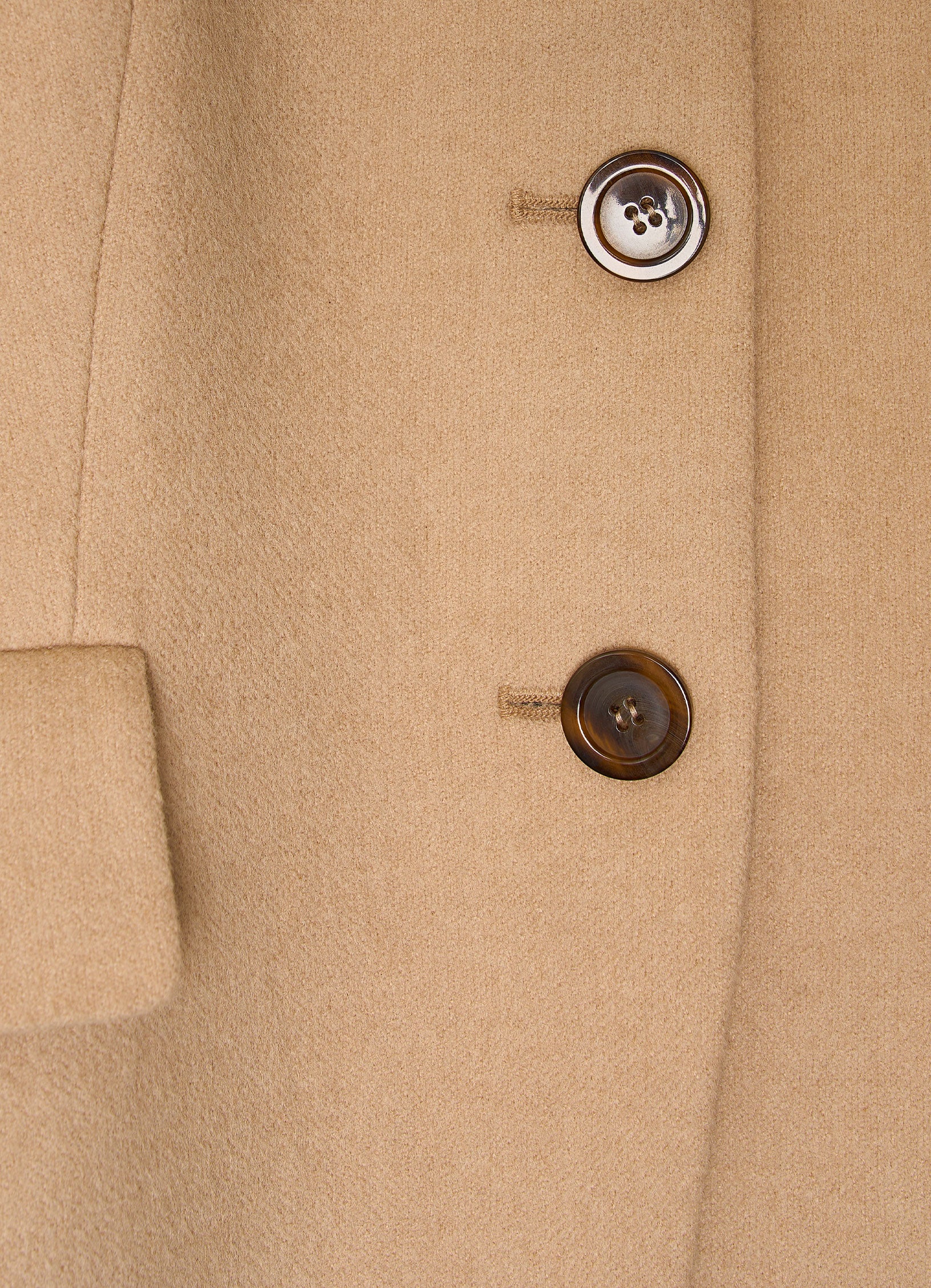 Detail of camel wool-cashmere jacket showing natural corozo buttons and refined textured fabric