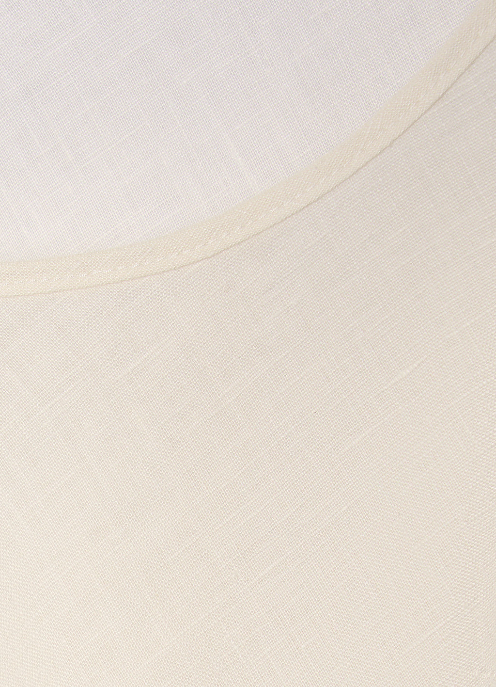 Detail of cream linen-blend top showing soft texture and neckline finish