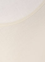 Detail of cream linen-blend top showing soft texture and neckline finish