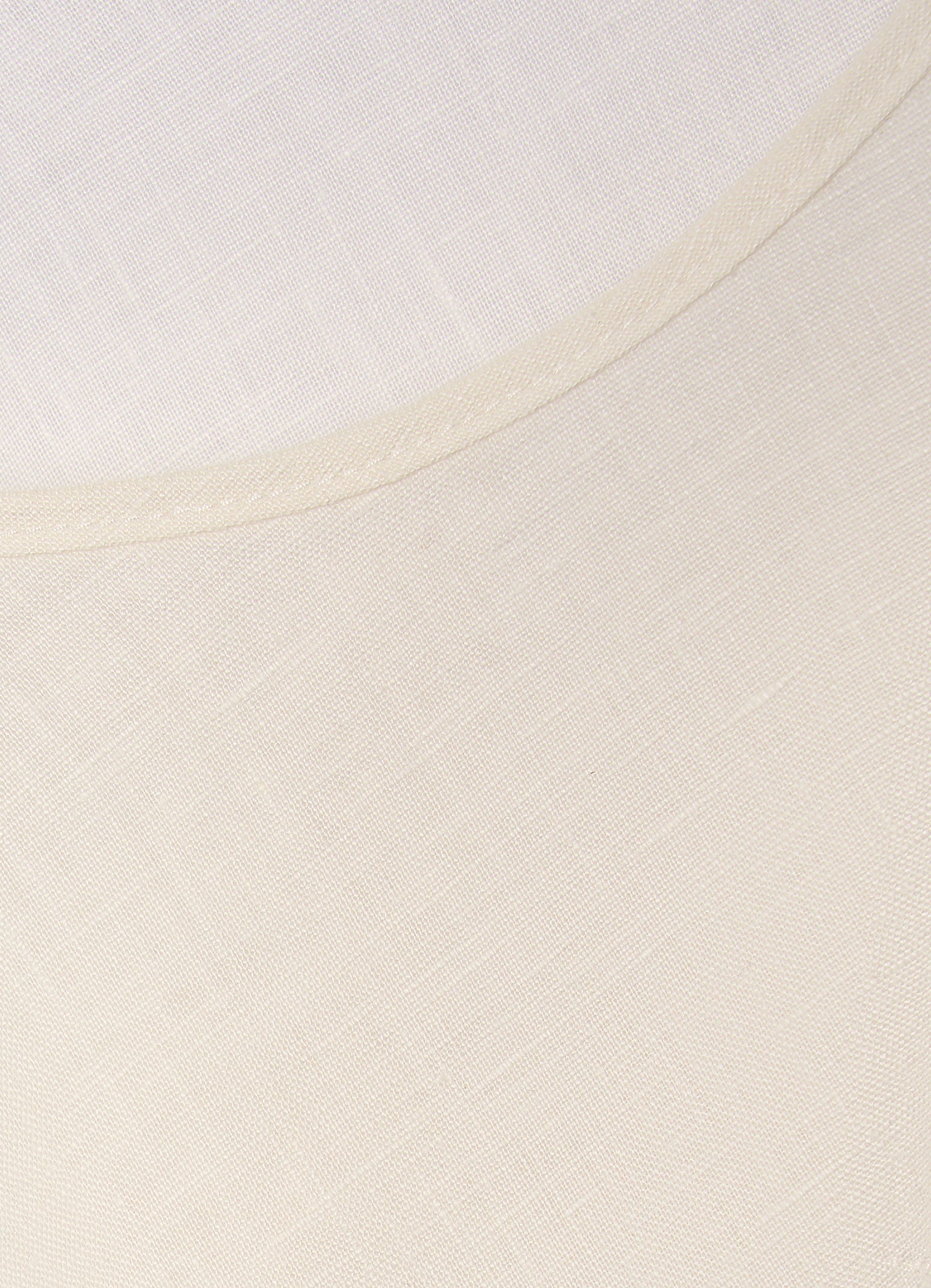 Detail of cream linen-blend top showing soft texture and neckline finish