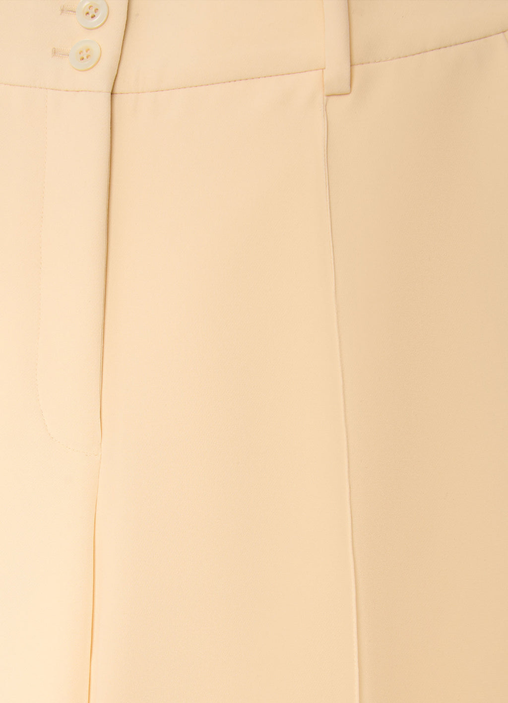 Detail of straight-leg tailored trousers with cuffs showing smooth structured fabric and tailored finish