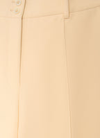 Detail of straight-leg tailored trousers with cuffs showing smooth structured fabric and tailored finish