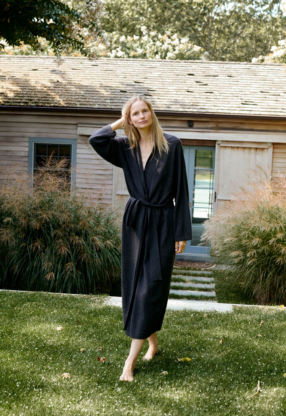 Model Katrin Thormann wearing SCHOENBACH long knit in a Hamptons garden setting