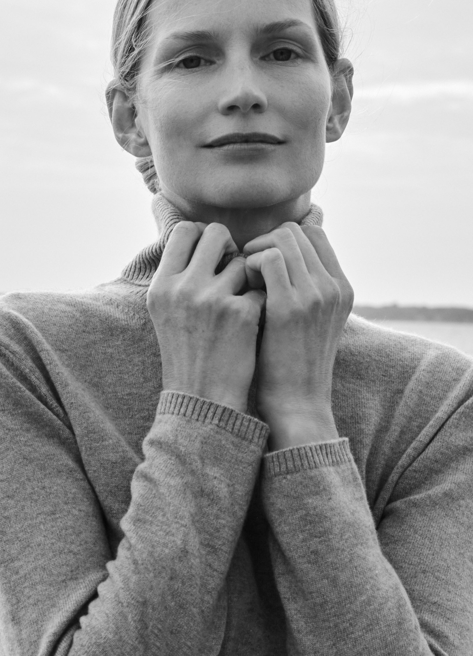 Close-up of model Katrin Thormann wearing light grey cashmere rollneck with ribbed collar