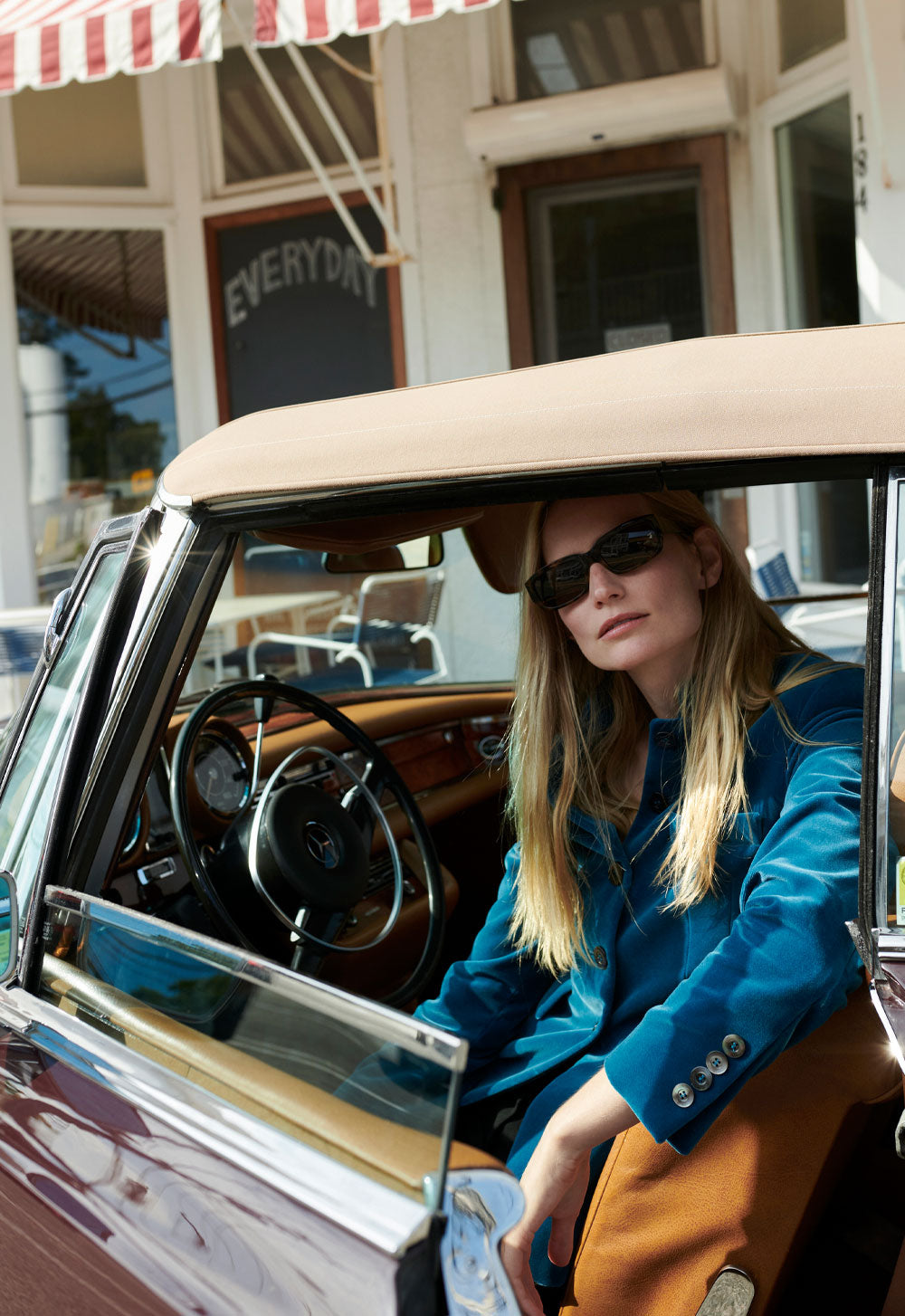 Model Katrin Thormann wearing SCHOENBACH petrol blue blazer in front of Marie Eiffel Cafe on Shelter Island