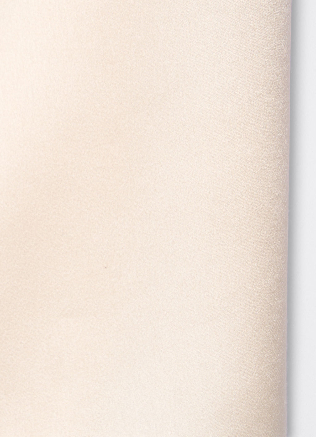 Detail of ivory satin trousers showing soft texture and fluid surface