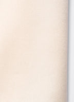 Detail of ivory satin trousers showing soft texture and fluid surface