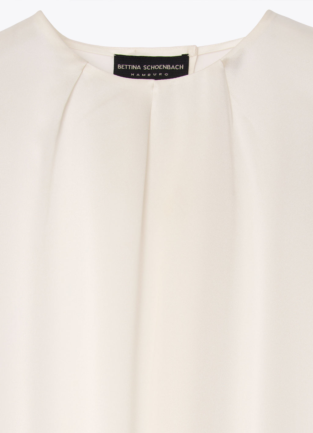 White silk blouse detail with round neckline and front pleat detailing