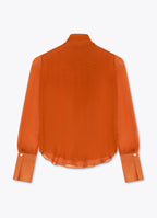 Back view of burnt orange silk bow blouse with sheer long sleeves