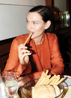 Model Sophie Grace Hirsch wearing sheer burnt orange silk blouse with elongated cuffs