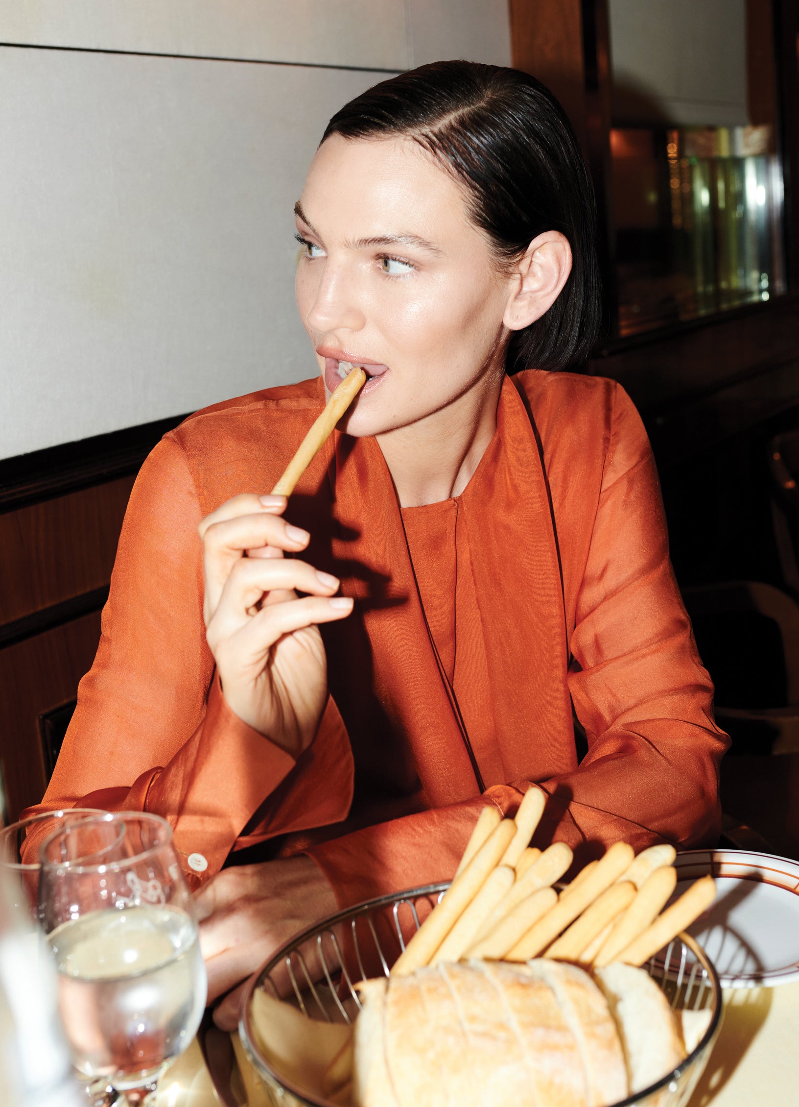 Model Sophie Grace Hirsch wearing sheer burnt orange silk blouse with elongated cuffs