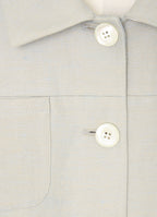 Close-up detail of button fastening and patch pocket on stone tailored jacket