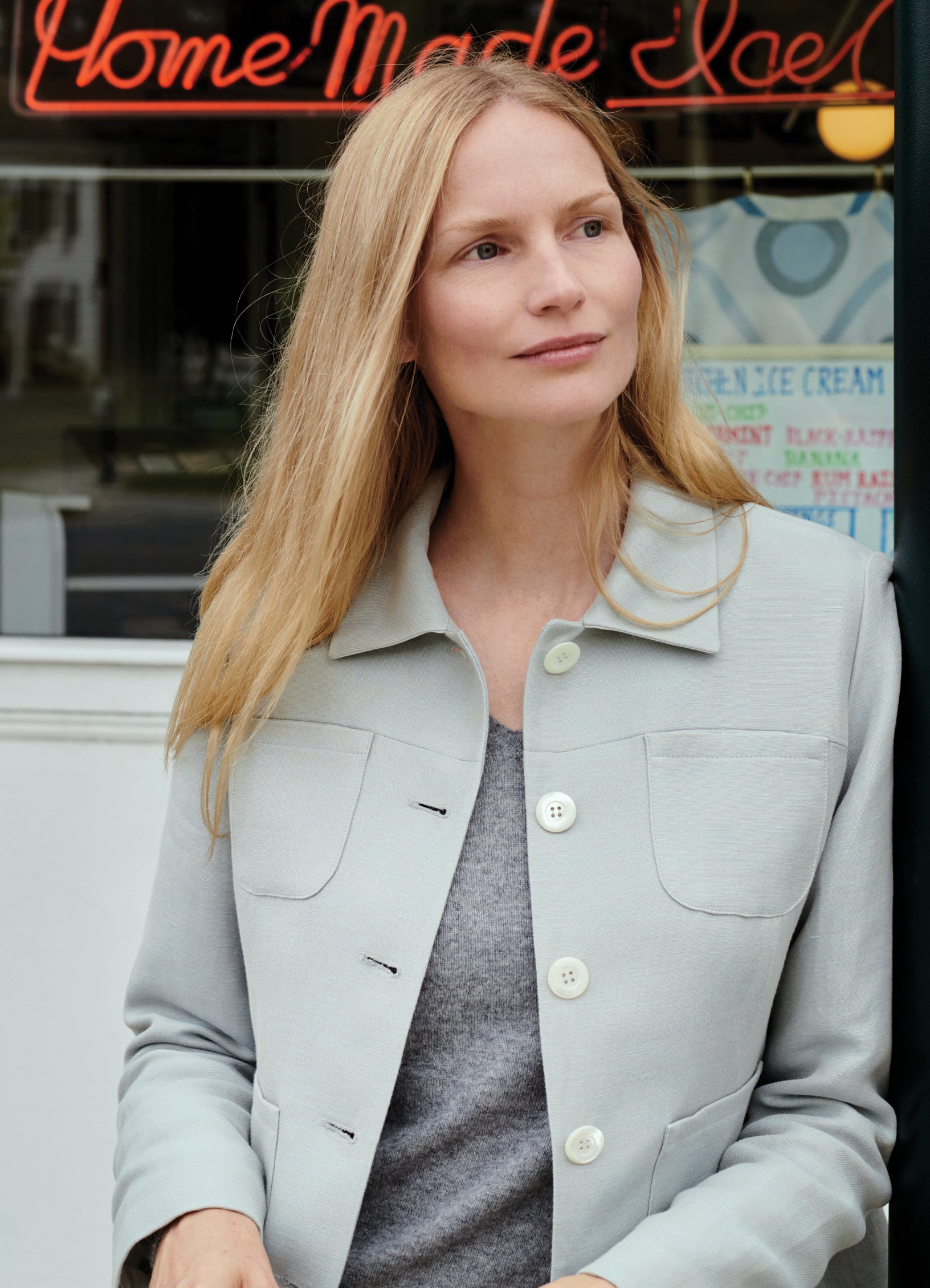 Close-up of model Katrin Thormann wearing stone tailored jacket with patch pocket detailing