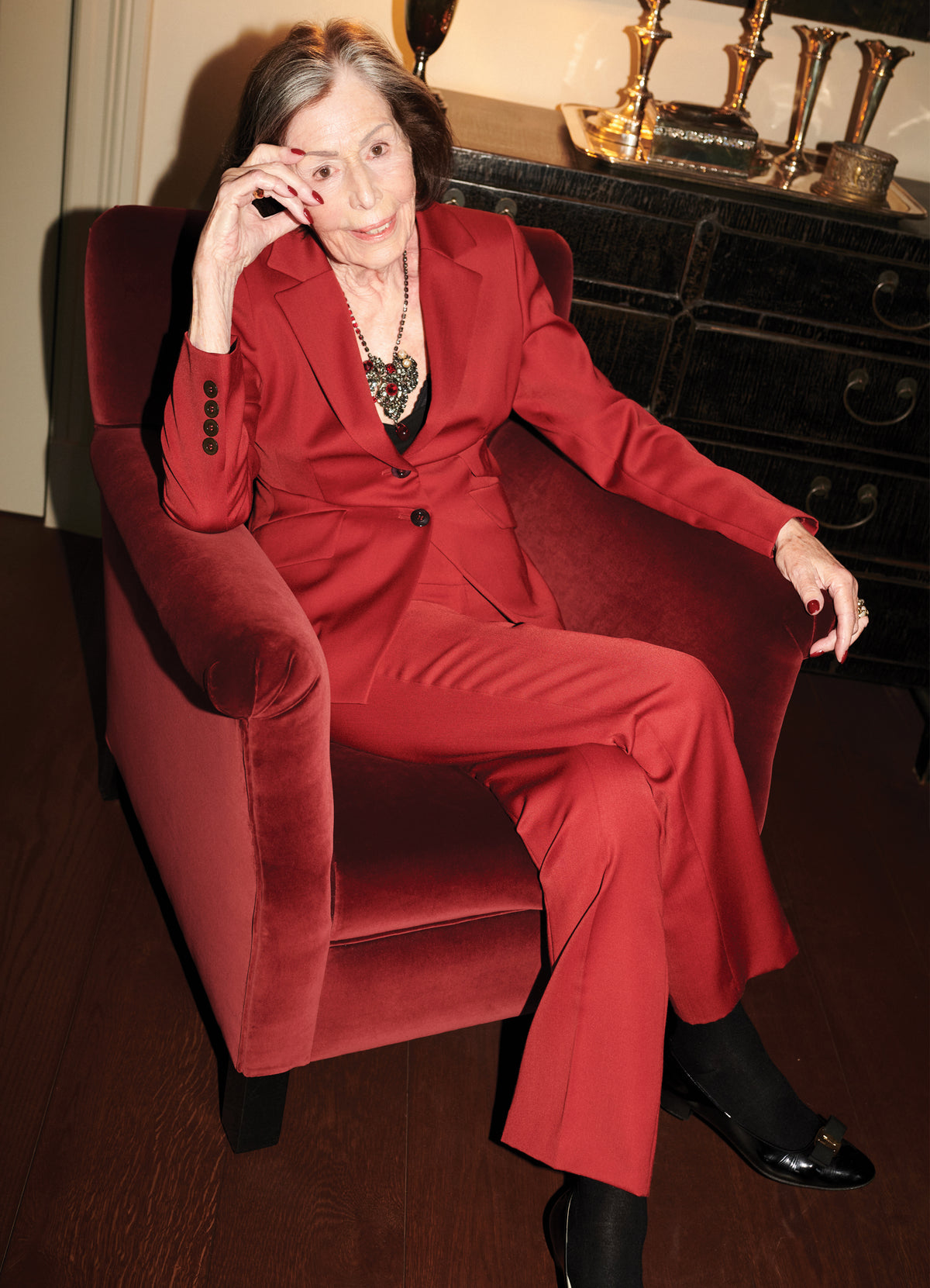 Model wearing SCHOENBACH red wool satin jacket and matching trousers, editorial full look