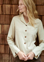 Sand wool-cashmere shirt jacket styled with relaxed tailoring against wooden backdrop
