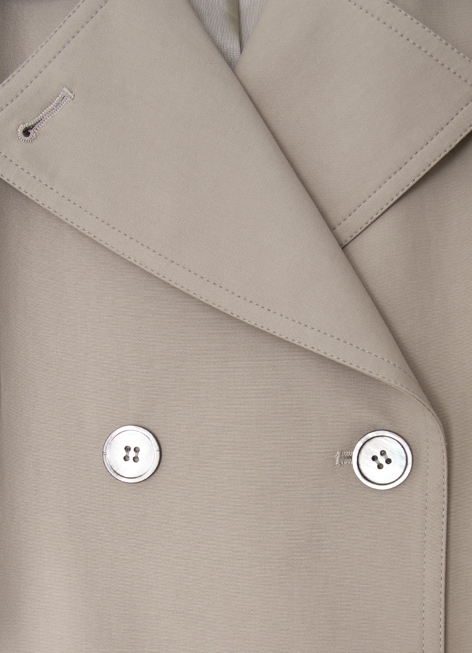 Taupe trench coat detail with mother-of-pearl buttons