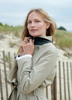 Taupe trench coat worn outdoors with structured collar