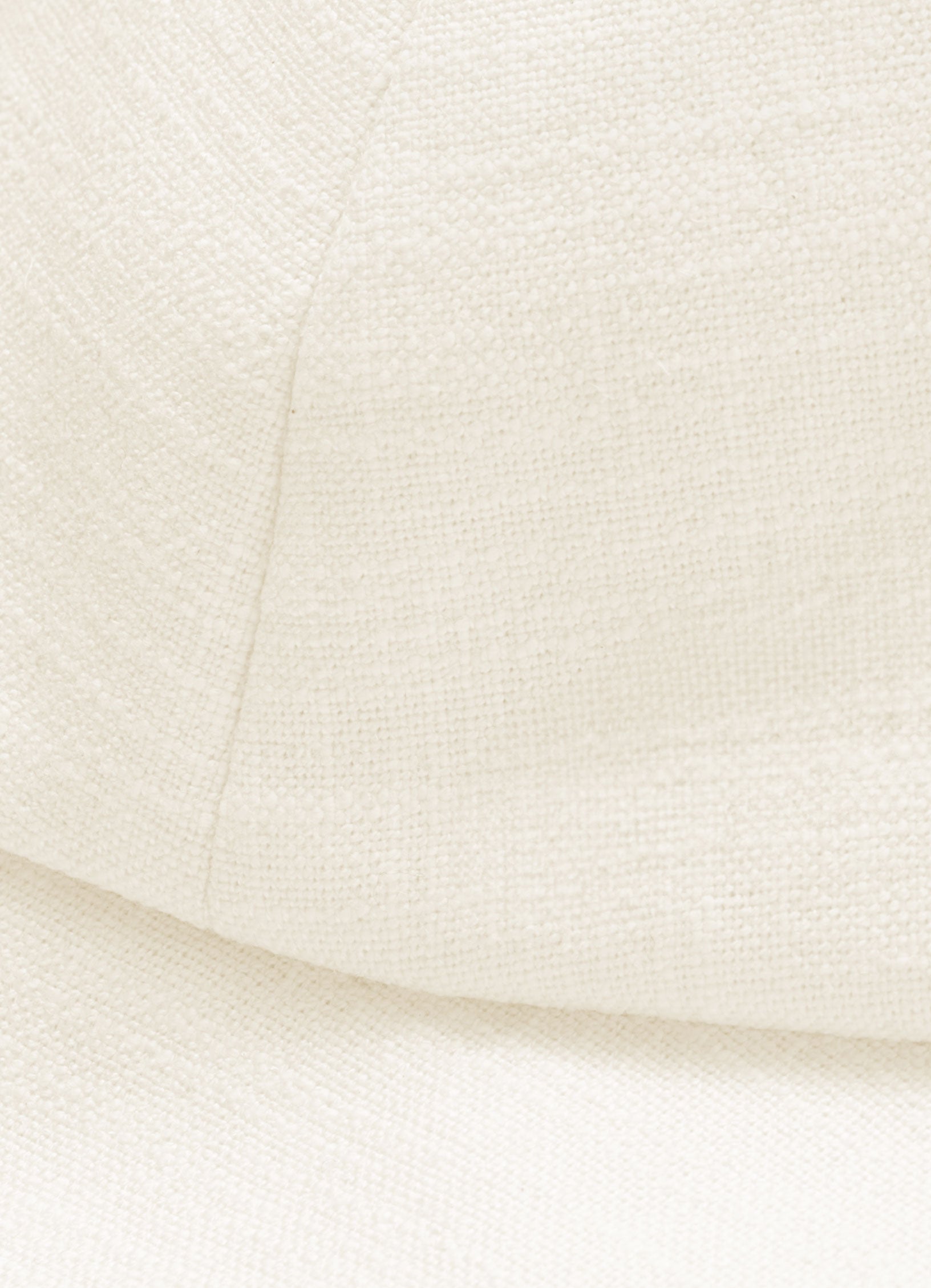 Close-up detail of textured linen cotton fabric on structured white sun hat