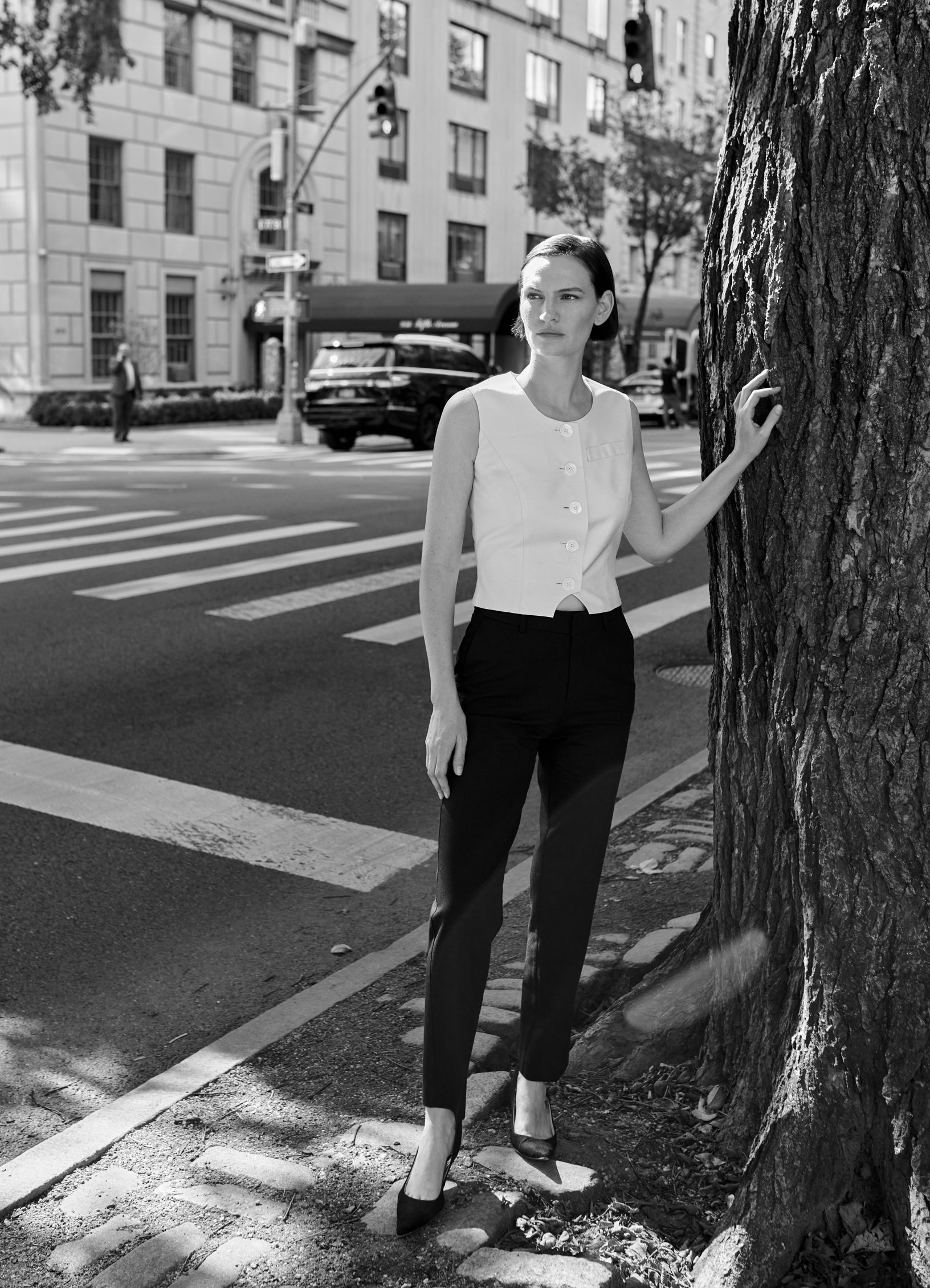 Model Sophie Grace Hirsch wearing the tailored vest in ecru styled with black tailored trousers and pointed heels in New York City.